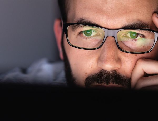 Mann mit Brille schaut nachdenklich nach vorn