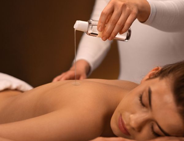 Frau liegt entspannt bei einer wohltuenden Aromamassage zur Stressbewältigung im Sommer