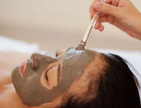 Frau mit Gesichtsmaske bei Wellness-Behandlung