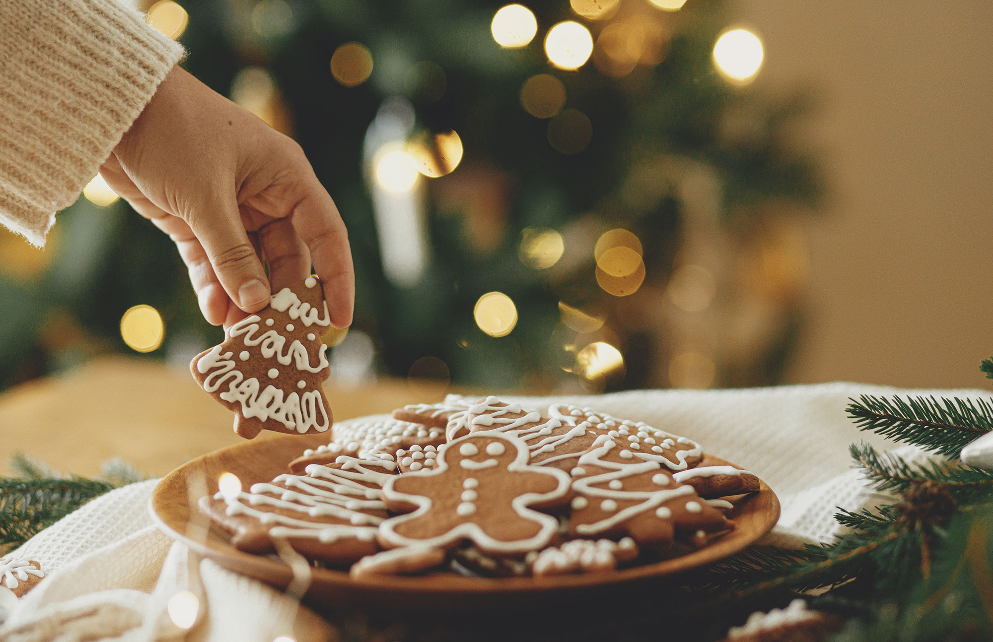 Teller mit Gebäck auf weihnachtlich dekoriertem Tisch.
