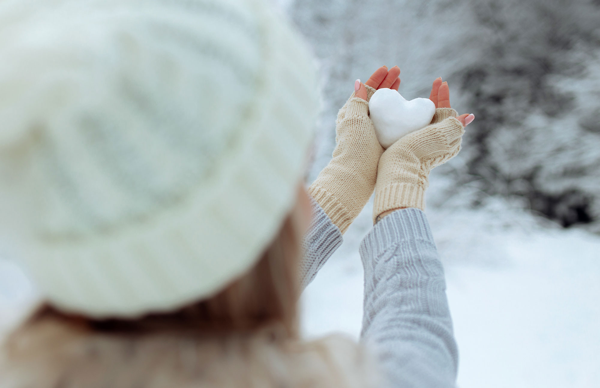 Hände mit Handschuhe halten Schnee-Herz