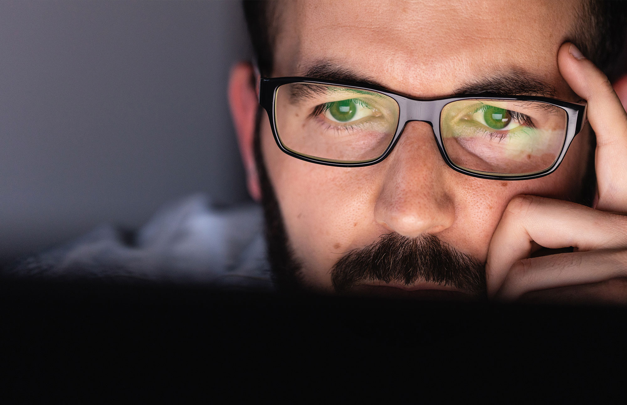 Mann mit Brille schaut nachdenklich nach vorn