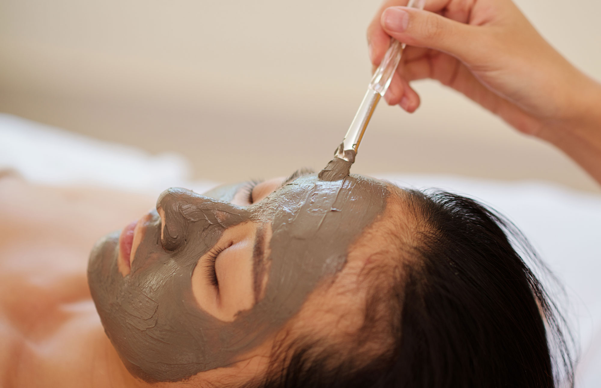 Frau mit Gesichtsmaske bei Wellness-Behandlung